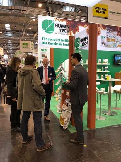 Foto vom Humintech Messestand, mehrere Personen die miteinander sprechen.